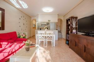 a living room with a red couch and a kitchen at BayMar by MarCalma in Montroig