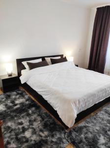 ein Schlafzimmer mit einem großen weißen Bett und einem Teppich in der Unterkunft Comfortable apartments in centre with 3 bedrooms in Riwne