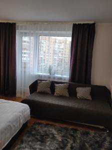 - un salon avec un canapé en face d'une fenêtre dans l'établissement Comfortable apartments in centre with 3 bedrooms, à Rivne