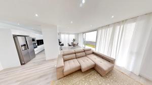 een woonkamer met een bank en een groot raam bij Villa Cassolino in Ribeira Brava +21 foto's