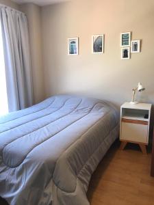 - une chambre avec un lit bleu et une table de chevet avec une lampe dans l'établissement Estudio Vasquitas Bariloche La mejor Ubicación, à San Carlos de Bariloche