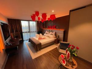 Innspire Hotel في ميونخ: غرفة نوم مع سرير وغرفة معيشة مع بالونات حمراء