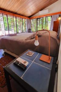 um quarto com uma cama e uma mesa com um candeeiro em Guest House & Art Gallery em Olinda