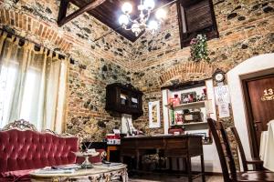 a room with a brick wall with a table and a piano at Bed & Breakfast Garrupa in Marcellinara