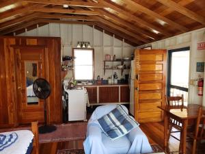 a kitchen with a couch in a room with wooden ceilings at Carolyn's Other House- Gold Standard Certified in Caye Caulker