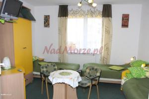 een woonkamer met een bank en een tafel en stoelen bij Naturalne Cuda i Przebudzenie Mocy in Gdynia