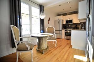 a kitchen with a table and chairs in a room at La Ruelle Hébergement in Saint-Siméon