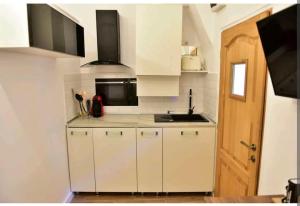 a small kitchen with white cabinets and a sink at Brukenthal Studio Sibiu in Sibiu +8 photos