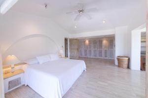 アカプルコにあるHermosa Villa Lontananza en Las Brisas, Acapulcoの白いベッドルーム(ベッド1台、天井ファン付) +10枚の写真