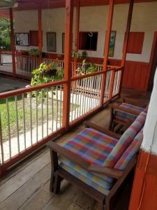 a porch with a couch and a chair on it at Hostal Rio Arabia - Valle De Cocora HOTEL in Salento