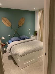 a bedroom with a bed with a green wall at « Côté Plage » appartement face mer in Le Portel