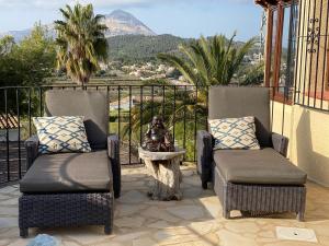 two chairs and a table on a balcony with a view at Little Bali Javea in Jávea