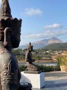 a statue of a woman sitting on a rock with a view at Little Bali Javea in Jávea