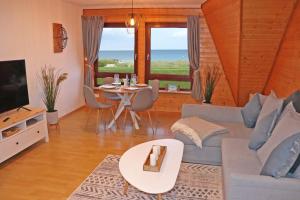 a living room with a couch and a table at Meerblick Apartment Bünning in Kalifornien