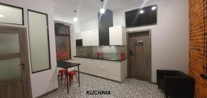 彼得库夫特雷布纳尔斯基Cosy Rooms的厨房配有白色橱柜、桌子和门