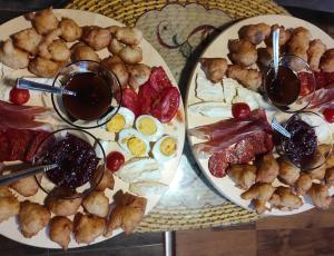 un tavolo con due piatti di cibo e due bicchieri di vino di Ethno house OSOBAK a Virpazar Altre 37 foto