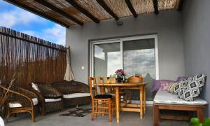 a patio with a table and chairs and a window at Olympus Family Pool Villa in Paralia Katerinis