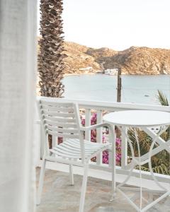 
a white chair sitting in front of a beach at Far Out Hotel & Spa in Mylopotas
