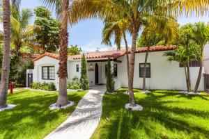 ein Haus mit Palmen davor in der Unterkunft Bars B&B South Beach Hotel in Miami Beach