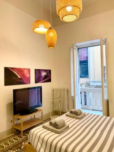 1 dormitorio con 2 camas, TV y ventana en L'Officina, en Bari