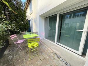 a patio with a table and four chairs on a patio at Maison à 6min du Parc Disneyland Paris in Magny-le-Hongre