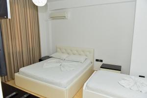 - une chambre avec un lit blanc et un matelas blanc dans l'établissement Hotel Tomorri, à Gramsh