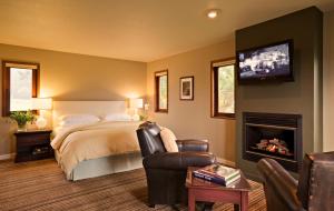 a bedroom with a bed and a fireplace and a tv at Brewery Gulch Inn & Spa in Mendocino