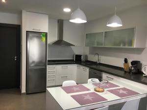 a kitchen with a refrigerator and a table with chairs at Apartamento Aqua Nature Delfin in La Mata