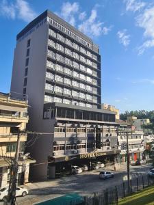 a tall building with cars parked in front of it at Hotel Europa in Blumenau