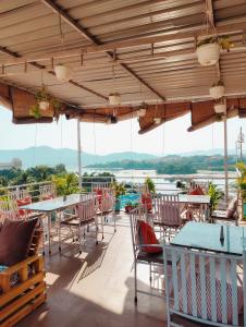a patio with tables and chairs and a view of the water at Musafir Hostel Udaipur in Udaipur