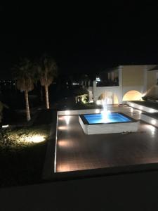 a swimming pool with a fountain at night at ERETRIA DIVINE SEA VIEW in Eretria