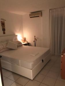 Un dormitorio con una gran cama blanca y una mesa en ERETRIA DIVINE SEA VIEW, en Eretria