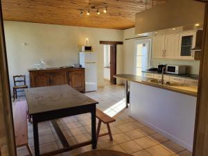 a kitchen with a counter and a table in it at Les écuries du chateau - 5 minutes Circuit des 24 H du MANS - 7 Personnes in Moncé-en-Belin