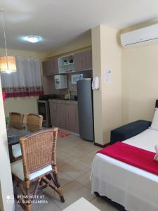 a bedroom with a bed and a table and a kitchen at Solar Pipa Praia Flats in Pipa
