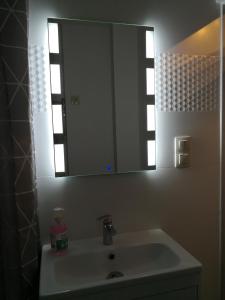 uma casa de banho com um lavatório e um espelho em Różowe sny em Kłodzko