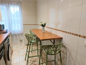 a small kitchen with a wooden table and green chairs at LA CASA DE CRISTINA Y NEREA - RIBADESELLA in Ribadesella +17 photos