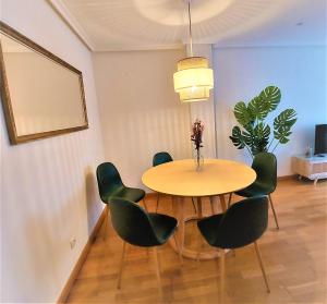 a dining room with a table and green chairs at LA CASA DE CRISTINA Y NEREA - RIBADESELLA in Ribadesella