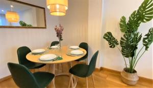 a dining room with a table and green chairs at LA CASA DE CRISTINA Y NEREA - RIBADESELLA in Ribadesella