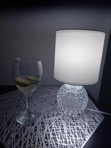 a wine glass and a lamp on a table at Apartament w Centrum Cichy Zakątek in Gliwice