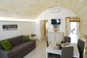 a living room with a couch and a table at La Naca dei Messapi Holiday Home in Mesagne