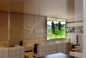 a living room with couches and a sign on the wall at Finca Prats Hotel Golf & Spa in Lleida