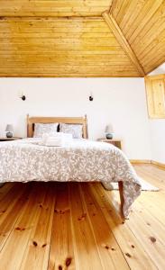 uma cama grande num quarto com tecto em madeira em Casa do Rio Alva em Arganil