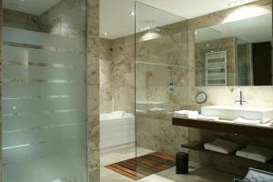a bathroom with a shower and a sink and a mirror at Finca Prats Hotel Golf & Spa in Lleida +23 photos
