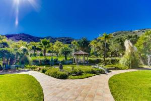 a path through a park with palm trees and a gazebo at Vineyard Hacienda in El Cajon