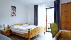 um quarto com uma cama de madeira e uma janela em Hotel Stierer em Ramsau am Dachstein