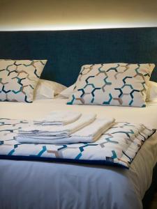 a bed with blue and white sheets and pillows at Hotel San Germano in Piedimonte San Germano