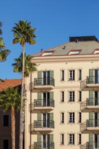 a tall building with palm trees in front of it at Hotel Windsor in Laigueglia