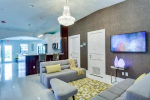 ein Wohnzimmer mit einem Sofa und einem TV in der Unterkunft Bars B&B South Beach Hotel in Miami Beach