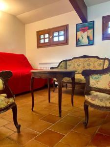 a living room with a table and two chairs and a couch at Eden Cottage in Saint-Gâtien-des-Bois