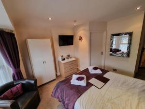 ein Schlafzimmer mit einem großen Bett und einem Stuhl in der Unterkunft The Fawley Guest house in Shanklin